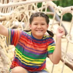 niña sonriente cruzando columpio